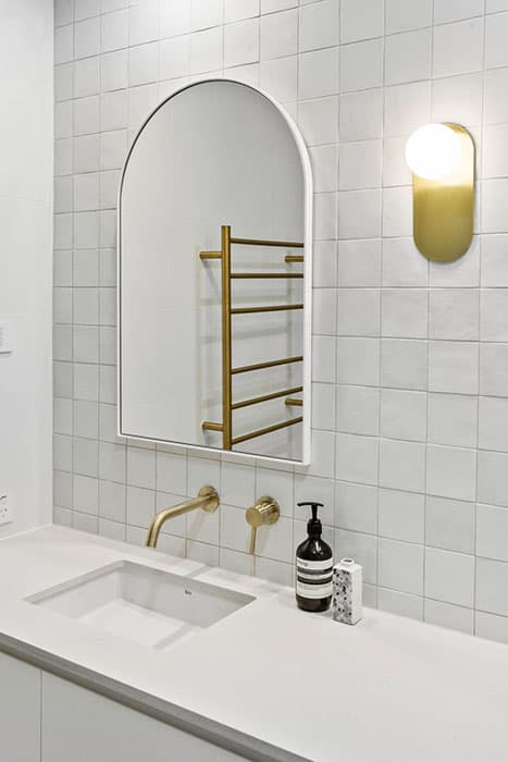 Modern bathroom renovation in Canberra with sleek design and gold fixtures