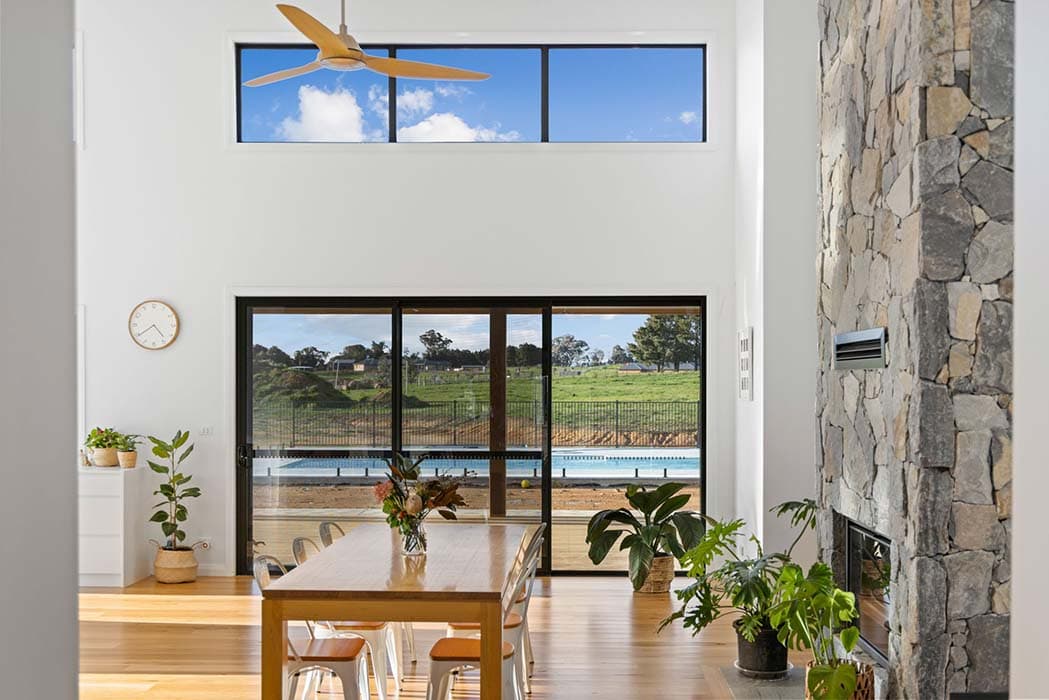 Modern living area with stone wall and large windows in Canberra, Australia
