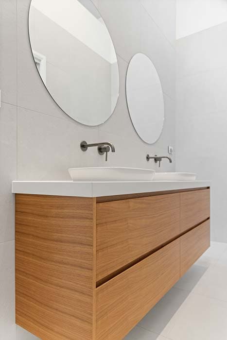 Modern bathroom renovation in Canberra with timber vanity and round mirrors