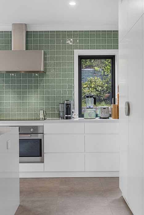 Modern kitchen renovation in Canberra with green tiles and sleek finishes