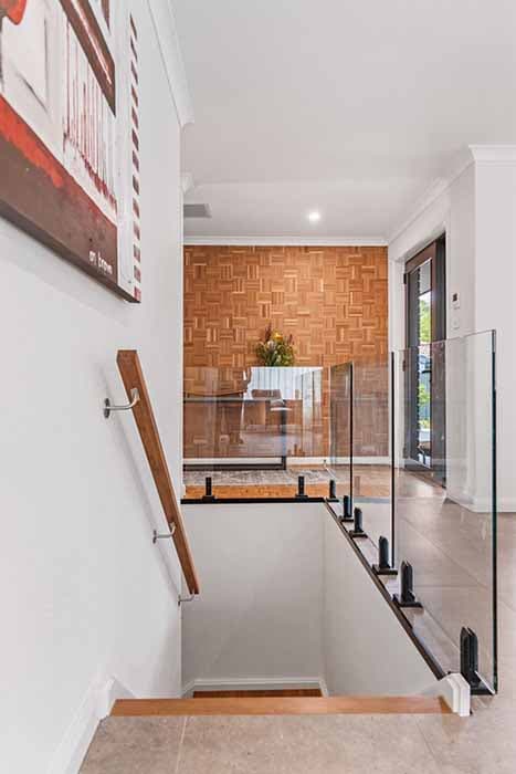 Modern staircase renovation in Canberra, Australia with wood panel feature wall.