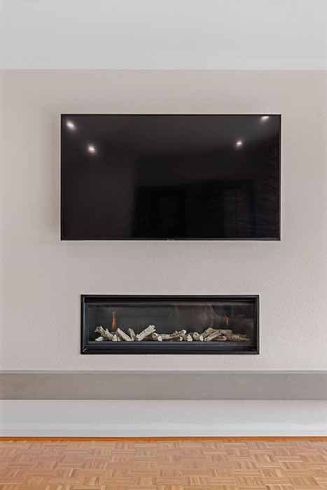 Modern living room renovation in Canberra with fireplace and TV