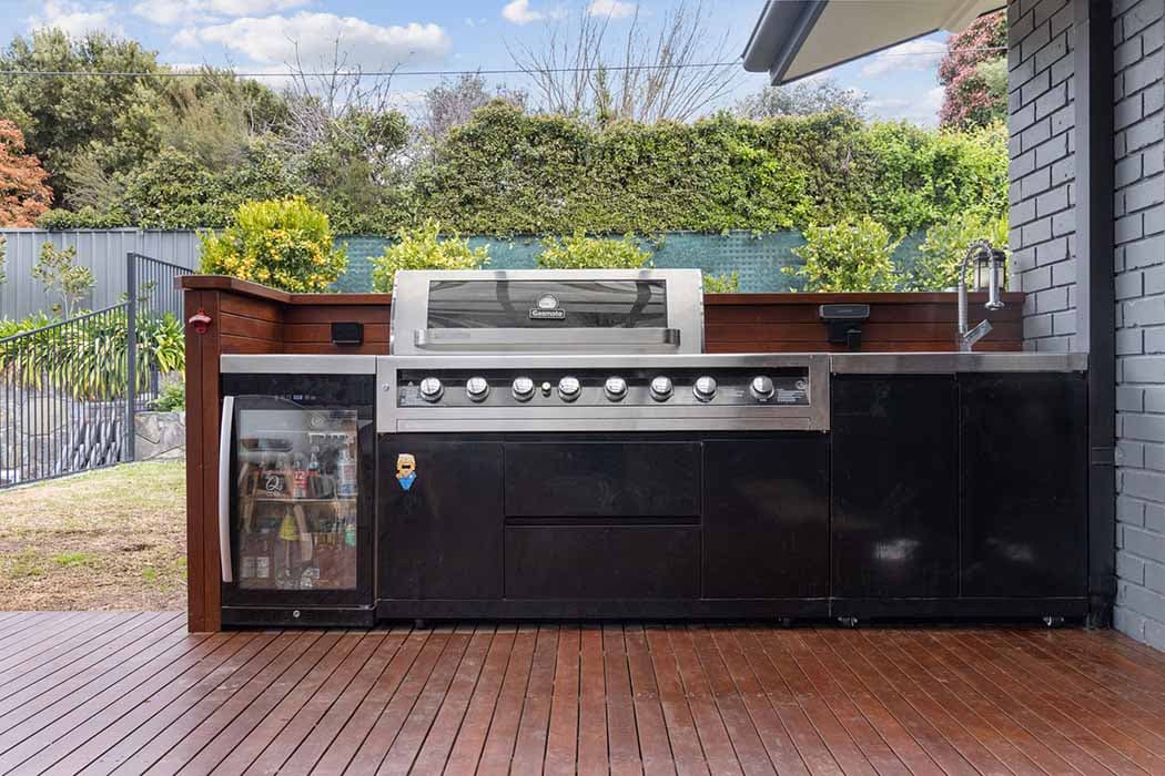 Outdoor kitchen renovation in Canberra, Australia with modern grill and wooden decking.