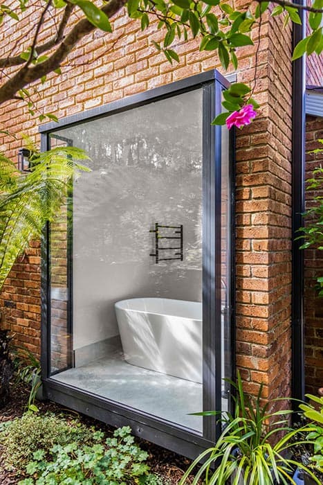Modern bathroom renovation in Canberra with freestanding tub and glass wall
