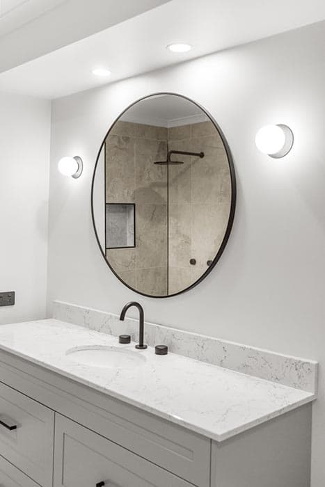 Modern bathroom renovation in Canberra, Australia with marble countertop and stylish fixtures.