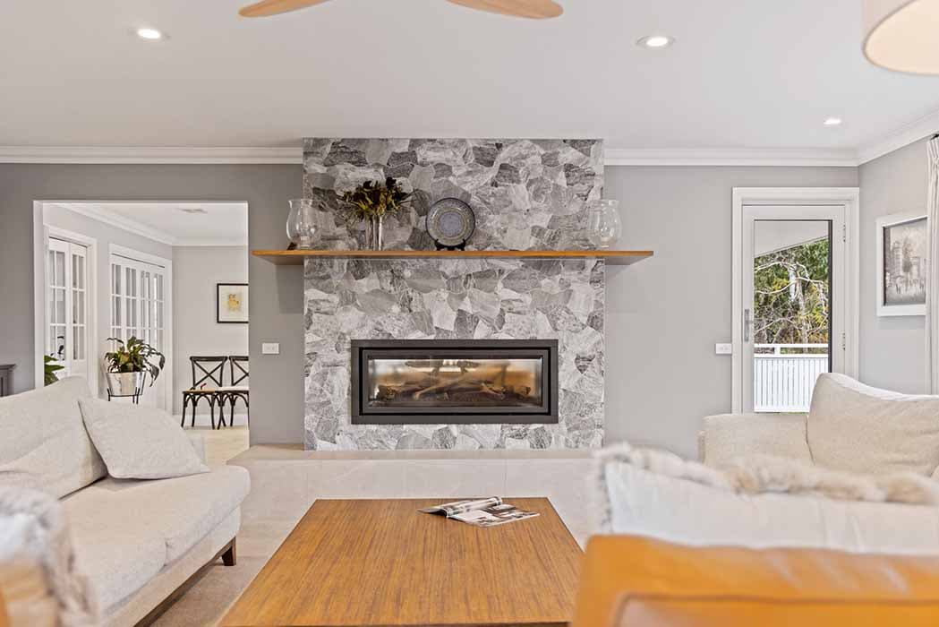 Stylish living room renovation in Canberra, Australia with stone fireplace and modern finishes.