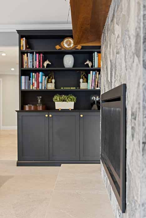 Stylish living room renovation in Canberra, featuring stone fireplace and black cabinetry.