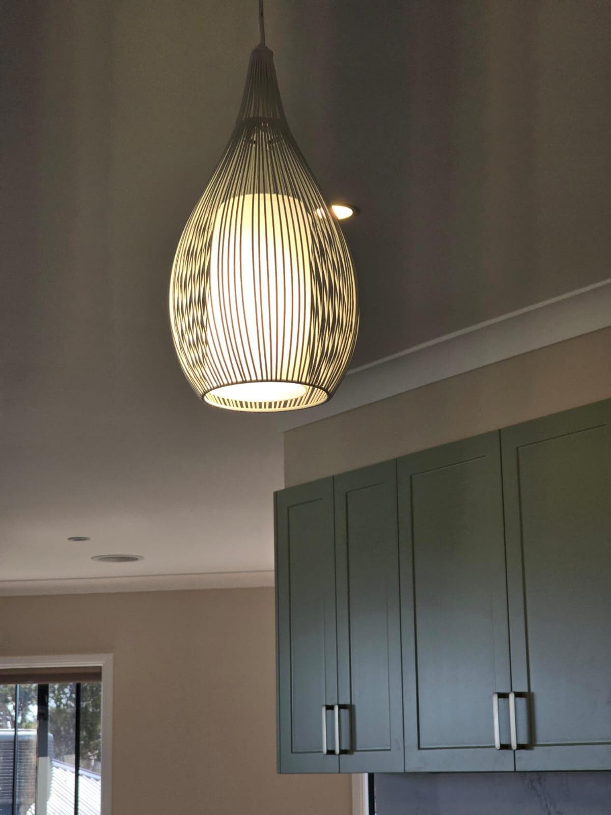 Modern kitchen renovation in Canberra with stylish pendant lighting and green cabinetry.