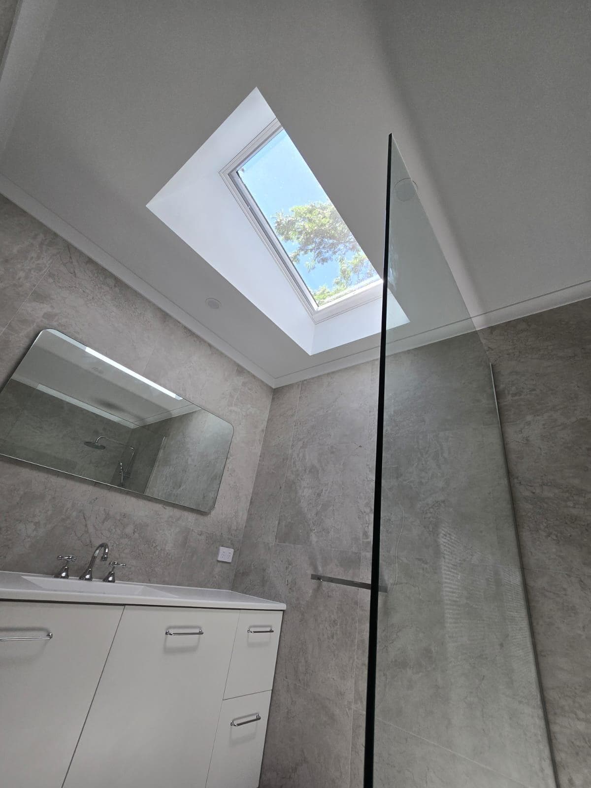 Modern bathroom renovation in Canberra with skylight and sleek finishes