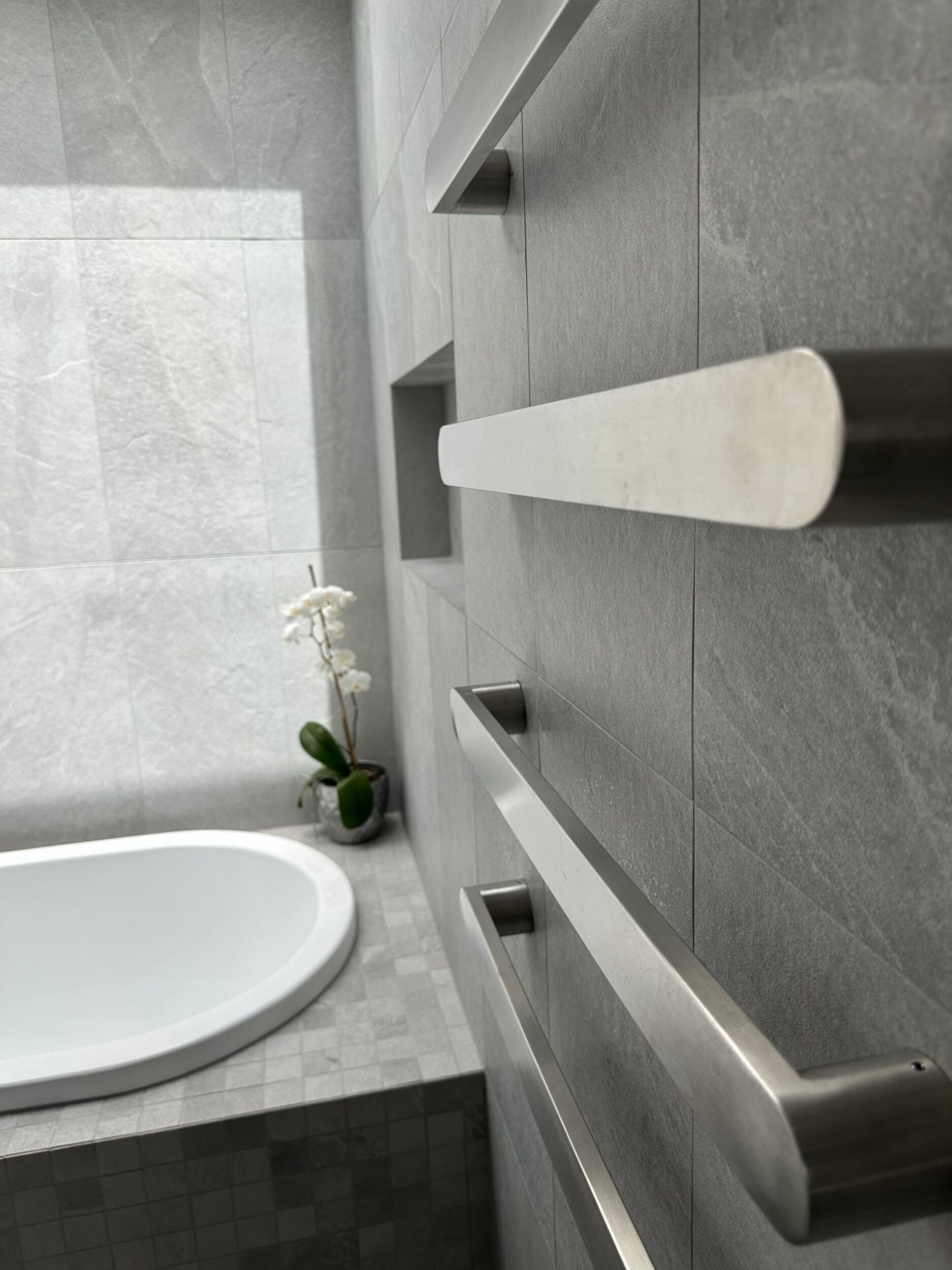 Modern bathroom renovation in Canberra with gray tiles and stainless steel fixtures