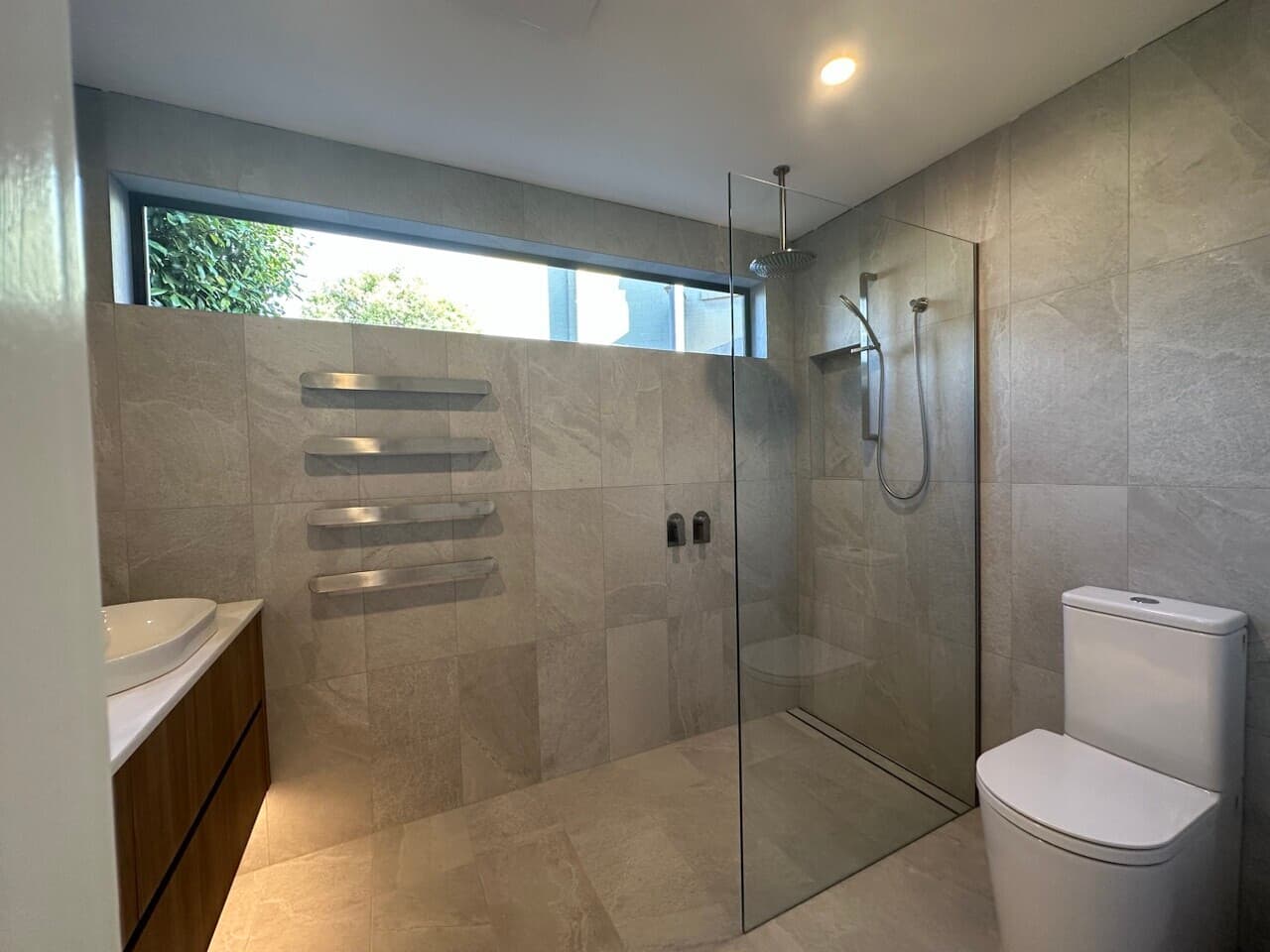 Modern bathroom renovation in Canberra, featuring sleek tiles and a walk-in shower.
