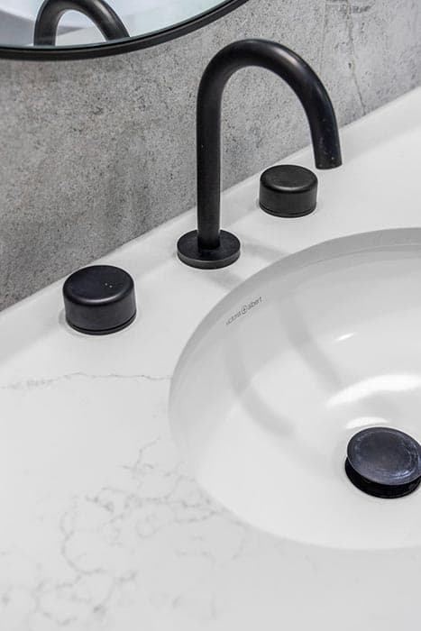 Modern bathroom renovation in Canberra with black fixtures and marble countertop